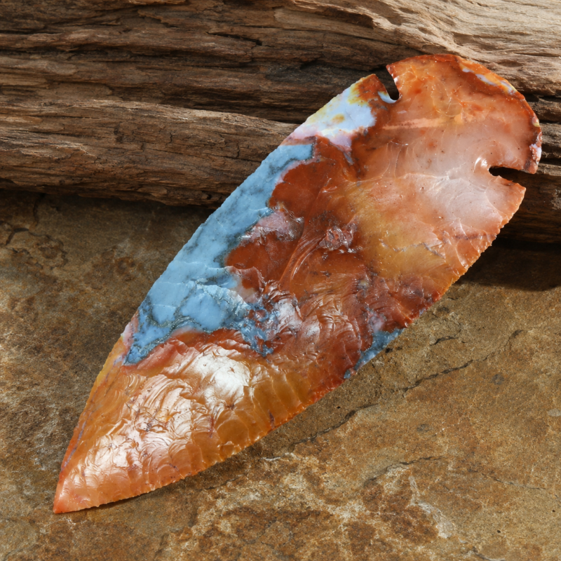 Handcrafted flintknapped Dovetail spear point made from Flint Ridge Chert by Joel Robinson featuring smoky blue-gray stone with vivid orange and red translucent edges.
