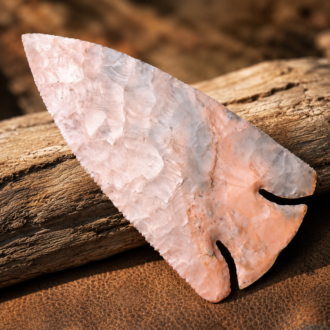 Handcrafted flintknapped Deep Notch Lost Lake spear point made from Flint Ridge Flint by Joel Robinson featuring soft pink, cream, and pale gray natural coloration.