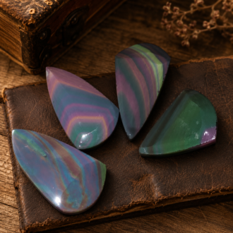 Four shaped rainbow obsidian preforms showing polished color bands before final flintknapping by Joel Robinson.