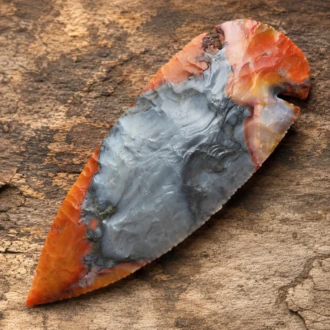 Dove Tail spear point flintknapped from Flint Ridge Chert with orange gray and cream patterns.