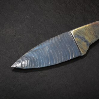 Handcrafted knife featuring a flintknapped Electric Blue Obsidian blade with a sculpted Labradorite handle by Joel Robinson.