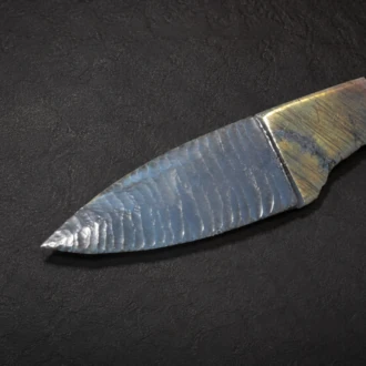 Handcrafted knife featuring a flintknapped Electric Blue Obsidian blade with a sculpted Labradorite handle by Joel Robinson.