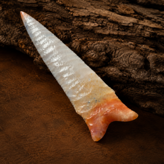 Handcrafted flintknapped Dalton spear point made from Agatized Florida Coral by Joel Robinson featuring translucent cream and soft orange natural color variations.